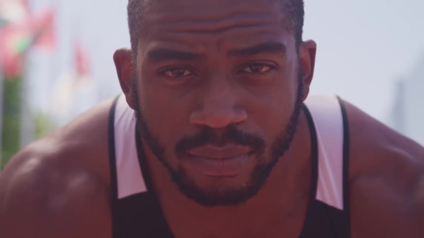 A muscular male athlete outside on a sunny day