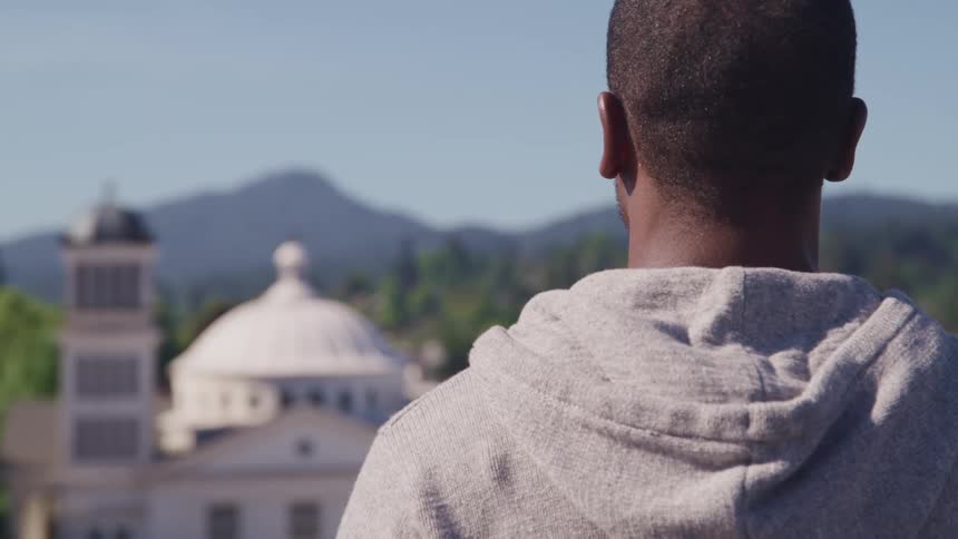 A man stands and looks at buildings