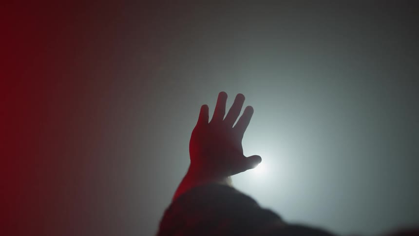 A person is reaching into the fog