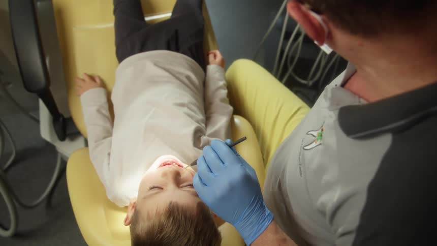 A child having his teeth worked on by a dentist