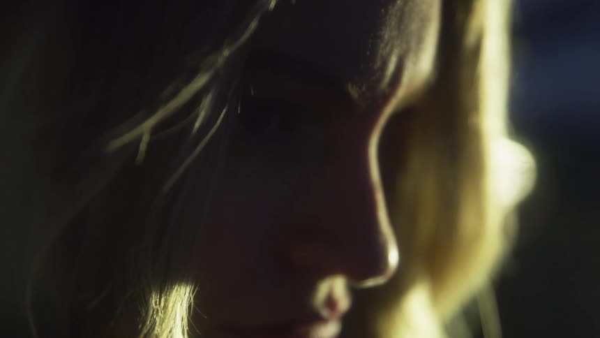 Silhouette of a young blonde womans face at night