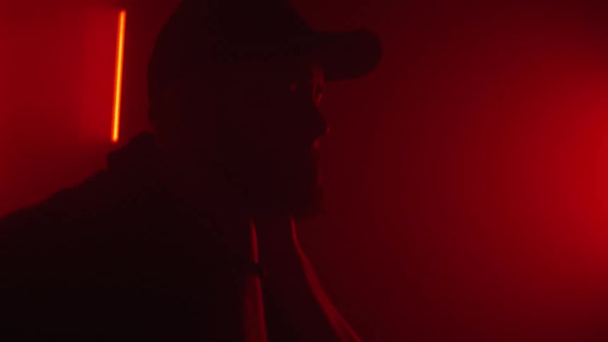 A man looks up in the dark room
