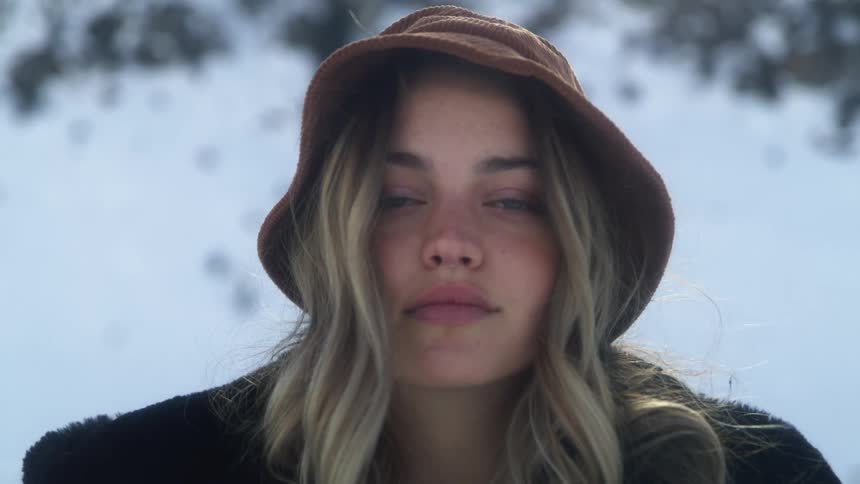 A young woman flipping her hair over her shoulder outside on a winter day