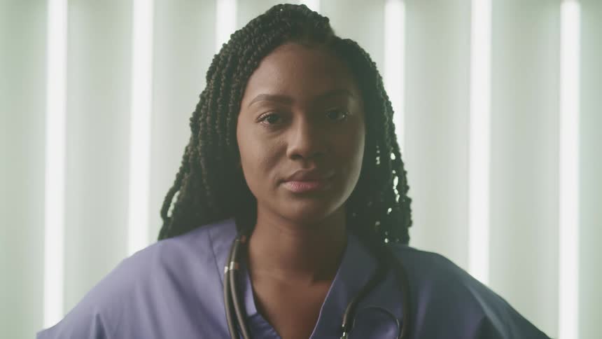 A portrait of a woman nurse standing in a room