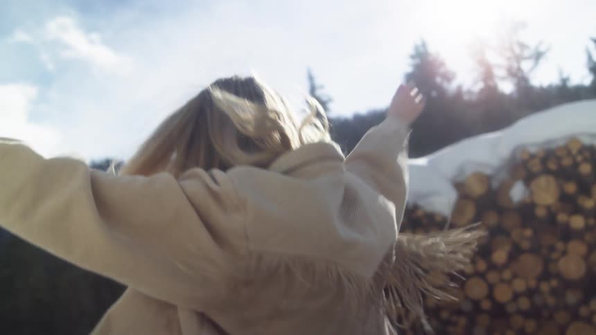 Happy young woman modeling for the camera in the mountains at winter