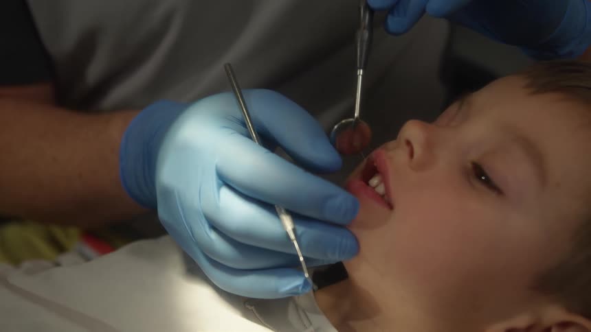 Dentist checks the theeth of a small boy