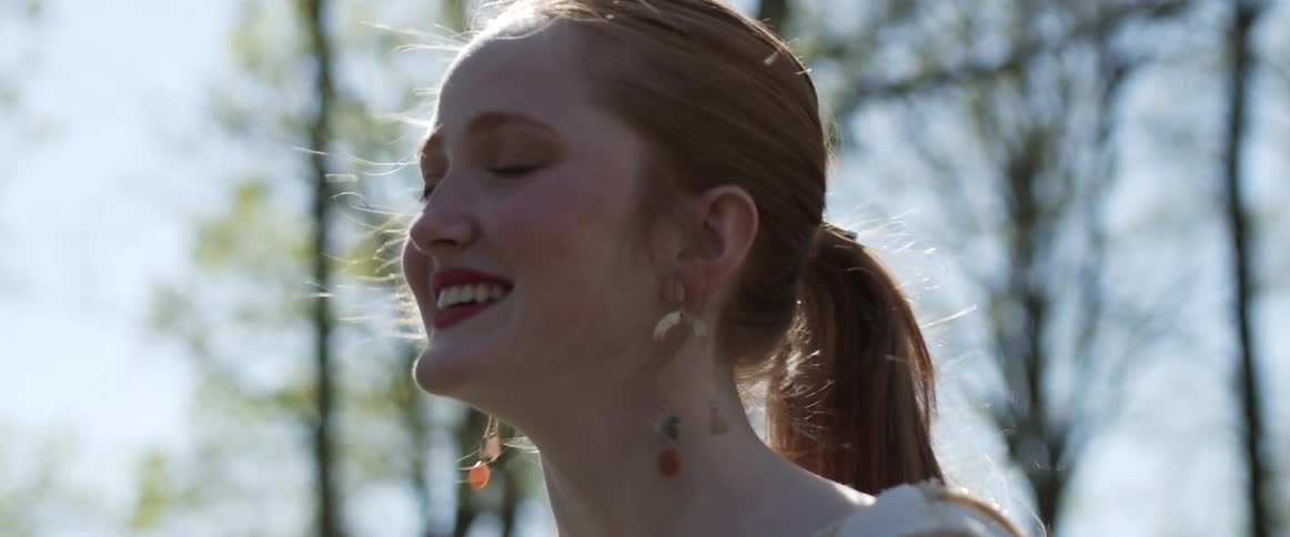 A portrait of a woman laughing outdoors