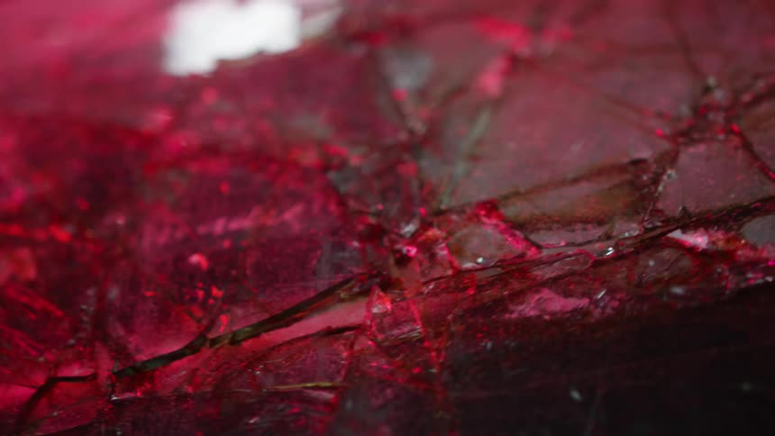 Red and blue light flashes on cracked broken glass and pavement