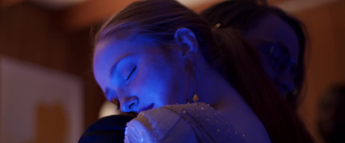 Man and woman dance romantically eyes closed in the led lights