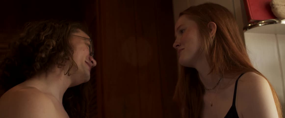 A man and woman talk and laugh at home