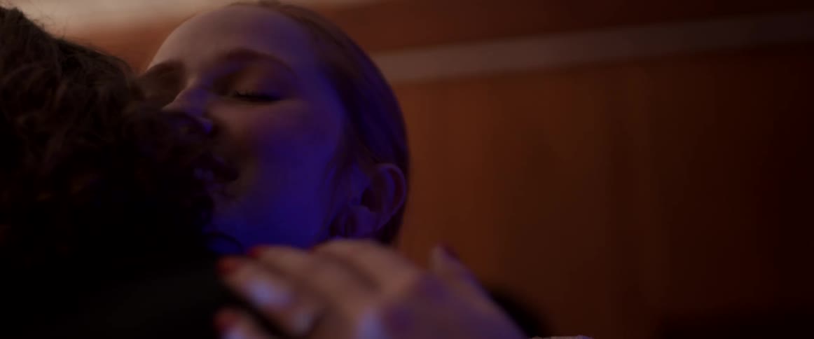 Woman hugging someone inside a dimly lit room