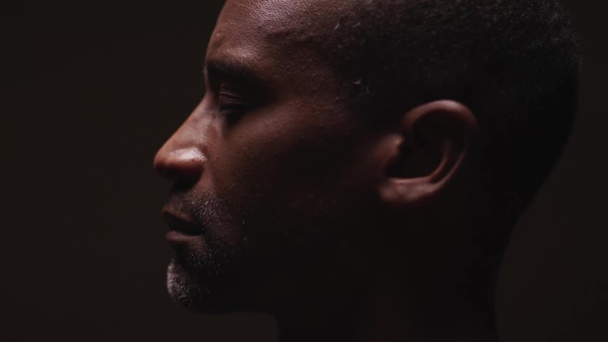 A man in a room with a wall in the background