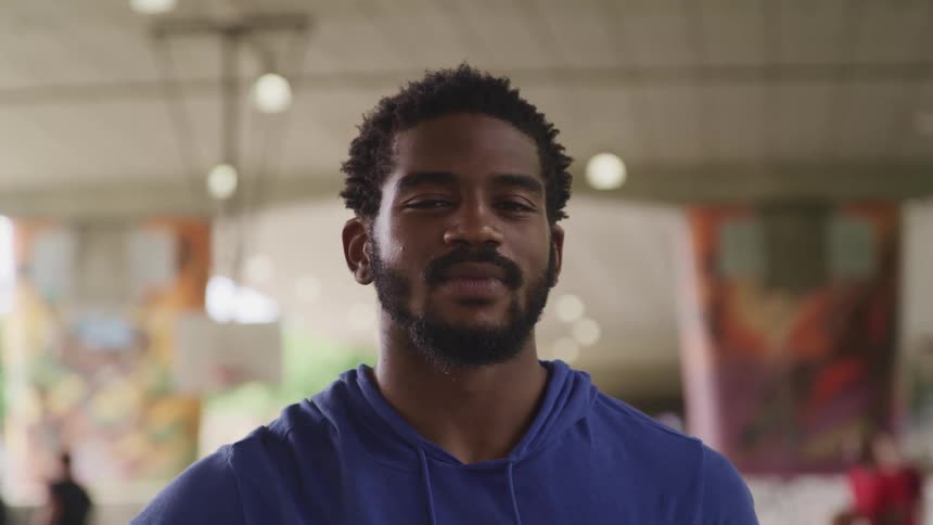Man standing in a basketball court looking at the camera