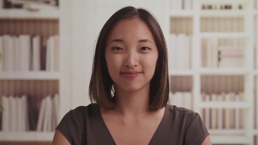 A portrait of a woman smiling in a room