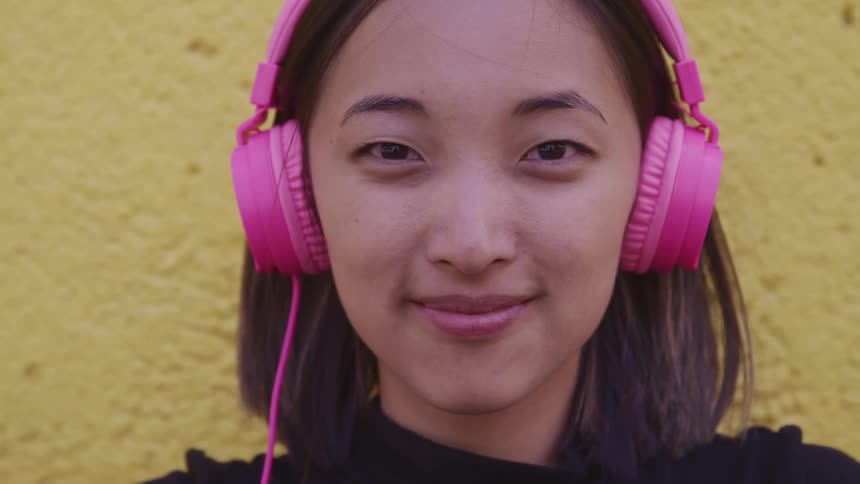 A woman wearing headphones standing outside