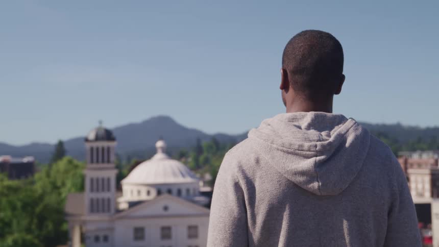 A man is looking over the city on a sunny day