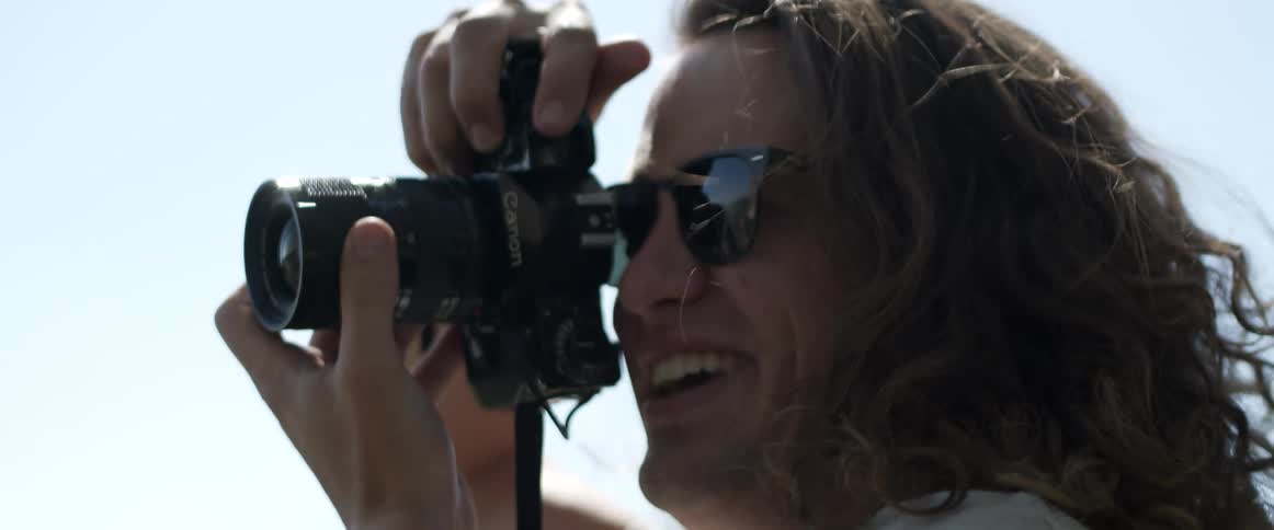 A man is taking photographs on a sunny day
