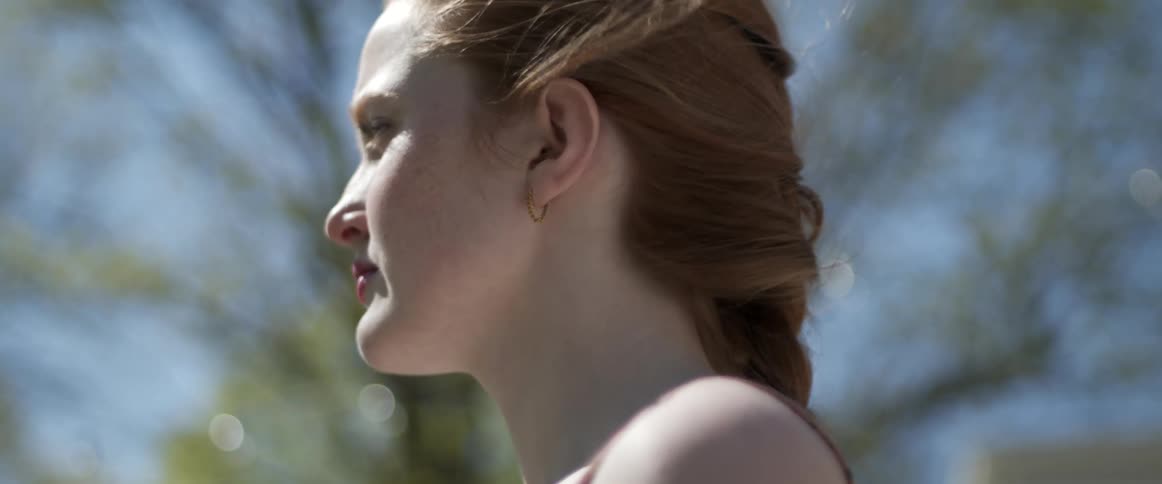 Young pale girl standing outdoors at daytime