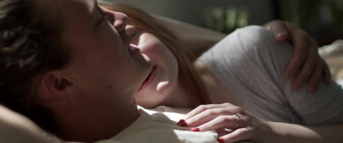 A man and a woman laying and hugging on a hammock