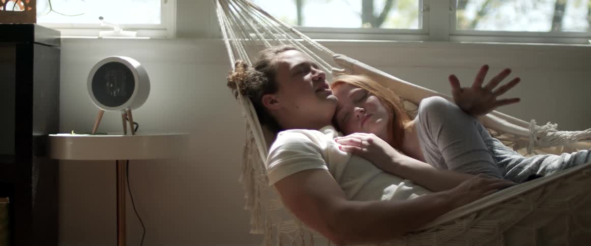 Two people laying in a hammock together