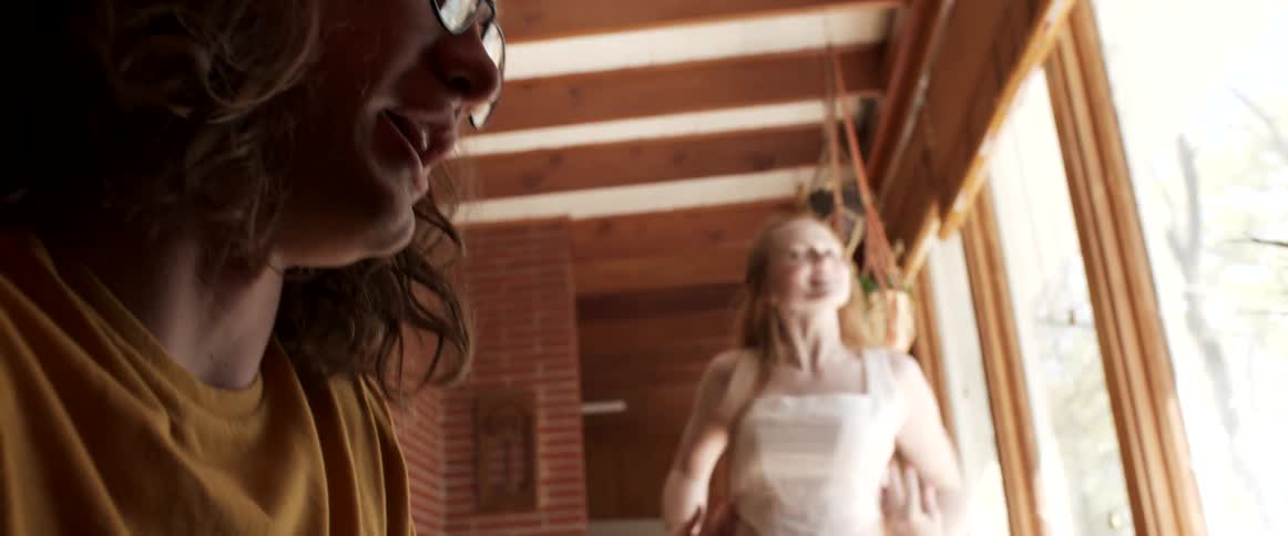 A woman dancing and spinning while a man sings and plays piano