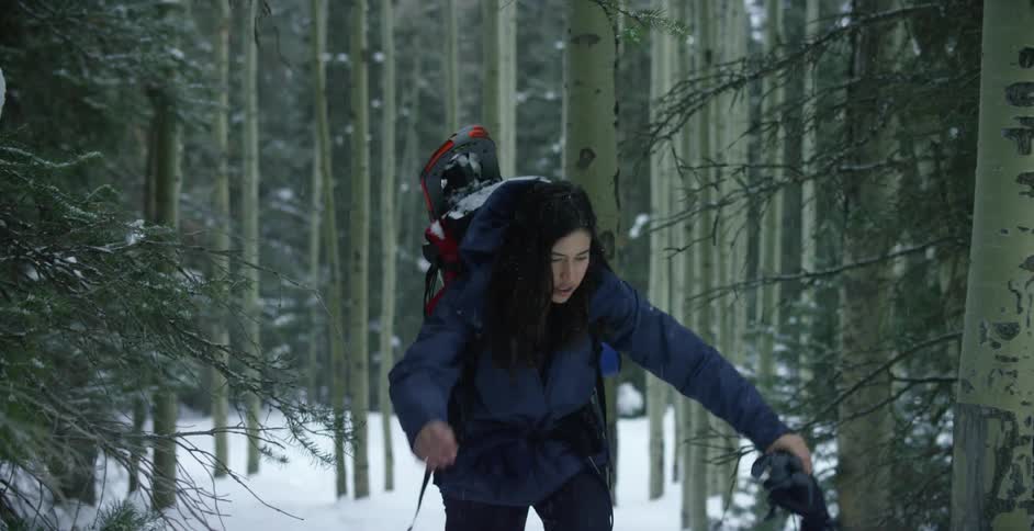 A woman hiking in the woods in the winter
