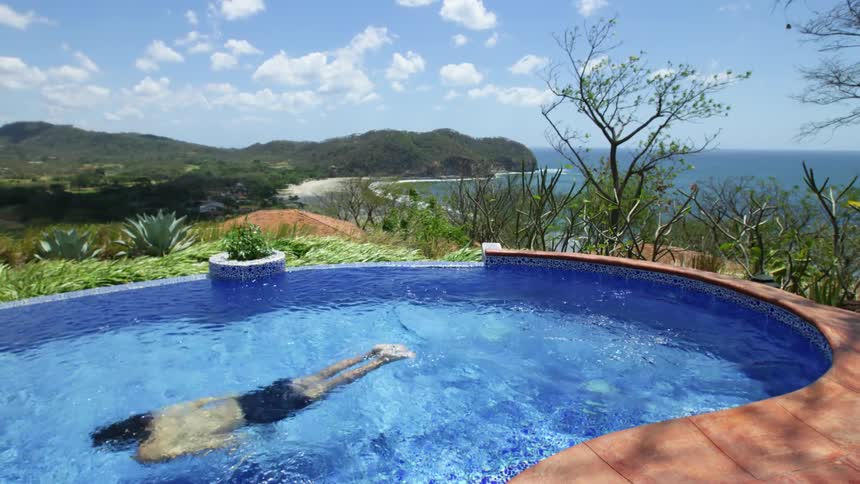 Man swimming in a pool near a beach