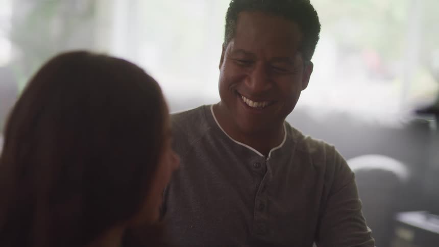 A father and his daughter smile and laugh at home