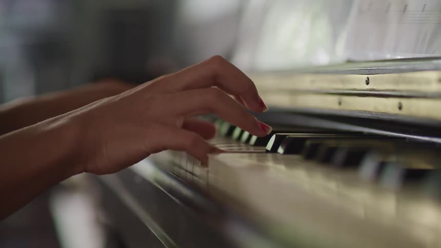 Young girl playing piano in a room at home