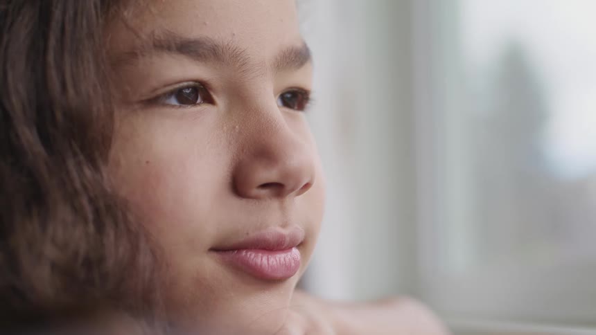 Close up of a girls face in a room at home