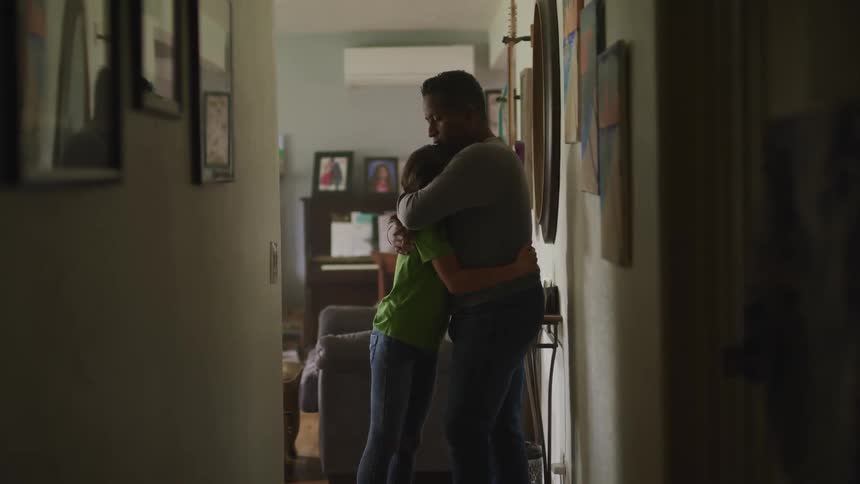 A father hugging his daughter in their house