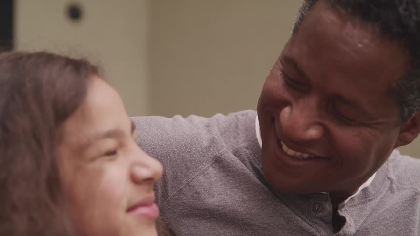 A father and young daughter smiling and laughing