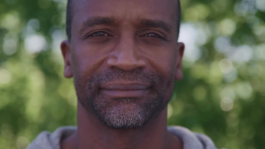 Close up of the face of a man looking at the camera outdoors