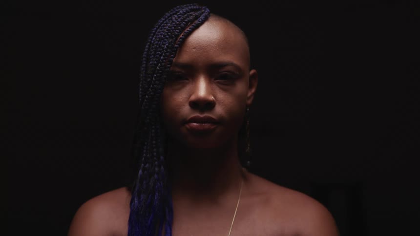 A black woman lifts her head and stares ahead proudly