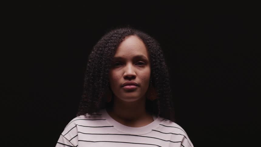 A woman standing in a room with a black background