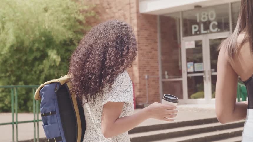 Two girls walking on the university campus at daytime