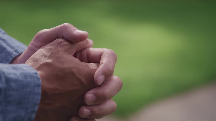 A view of a person that is holding their hands together
