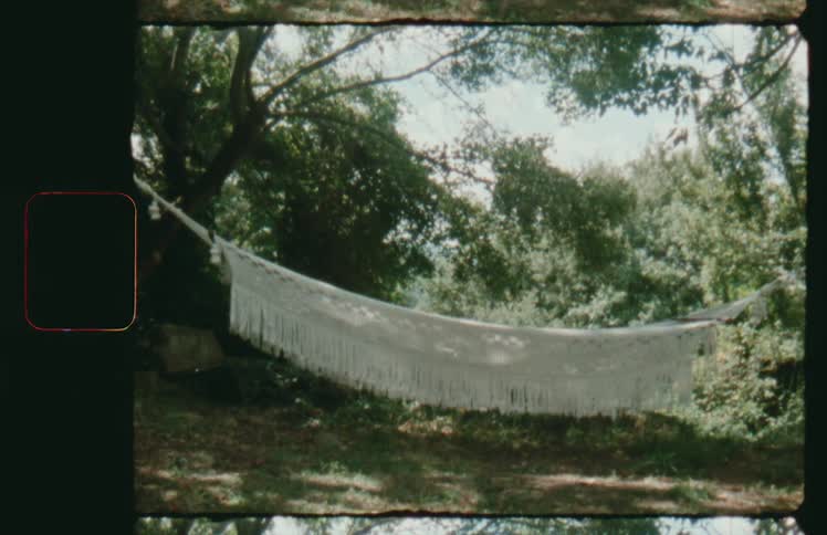 Vintage footage of macrame hammock between trees