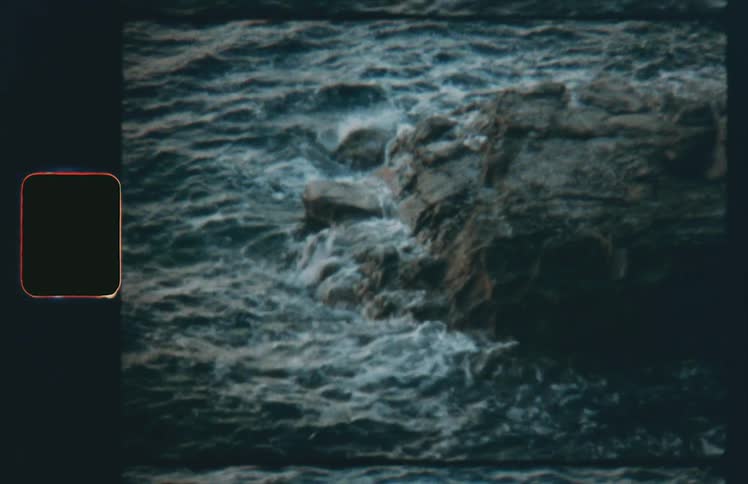 Ocean waves crash against a rocky shoreline