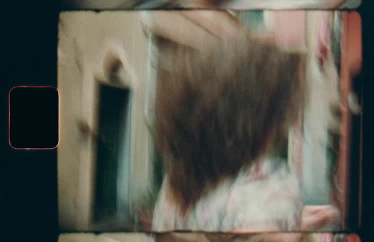 A woman with her arm reaching behind her pulls a companion with her as she runs down a street