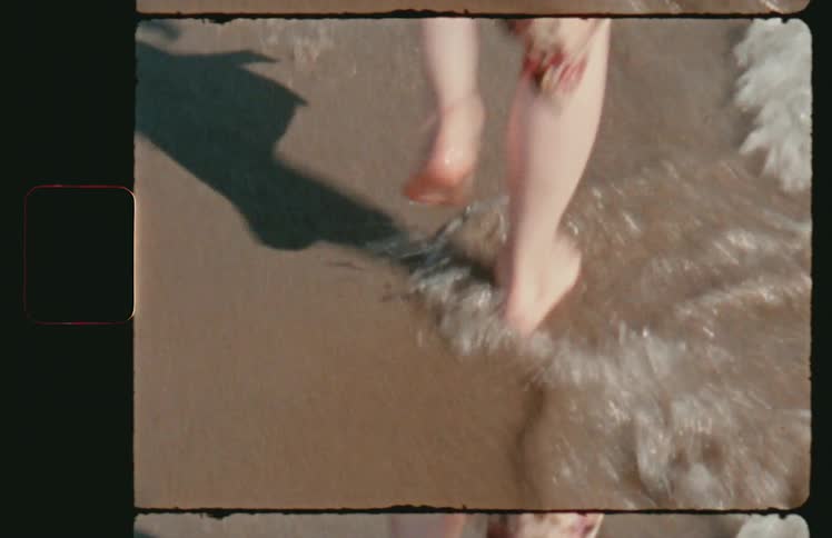 A woman walks in the water on the beach