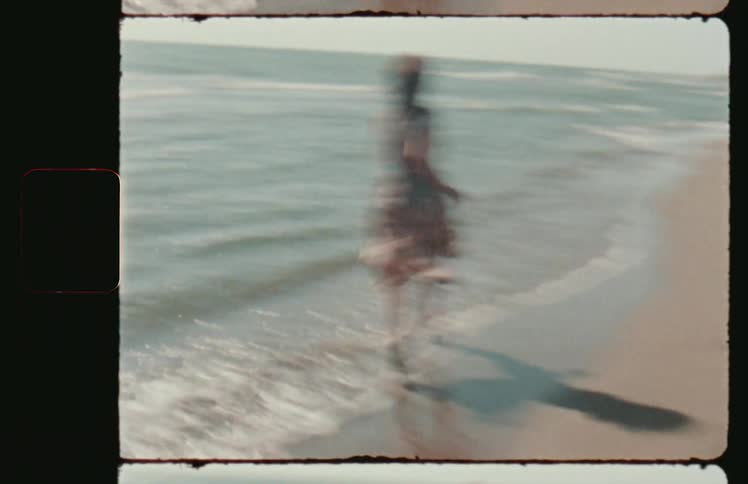 A woman in a sundress runs playfully on a sandy beach