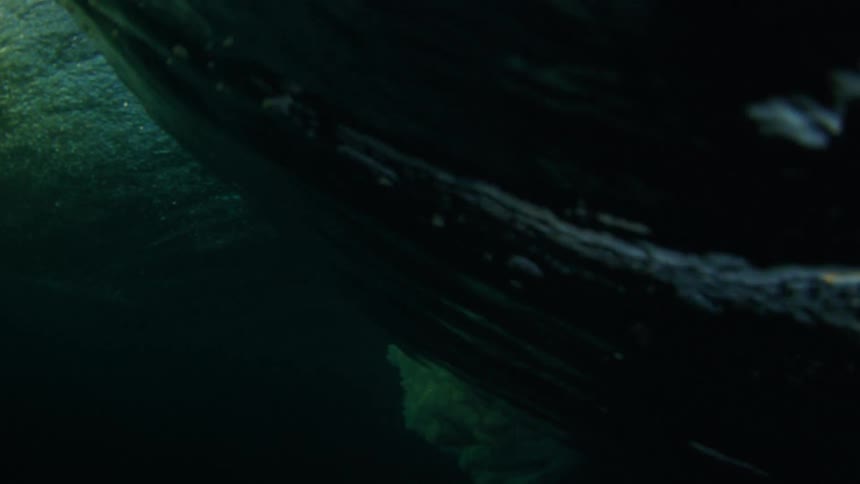 The ocean underwater with waves with the sky and clouds above