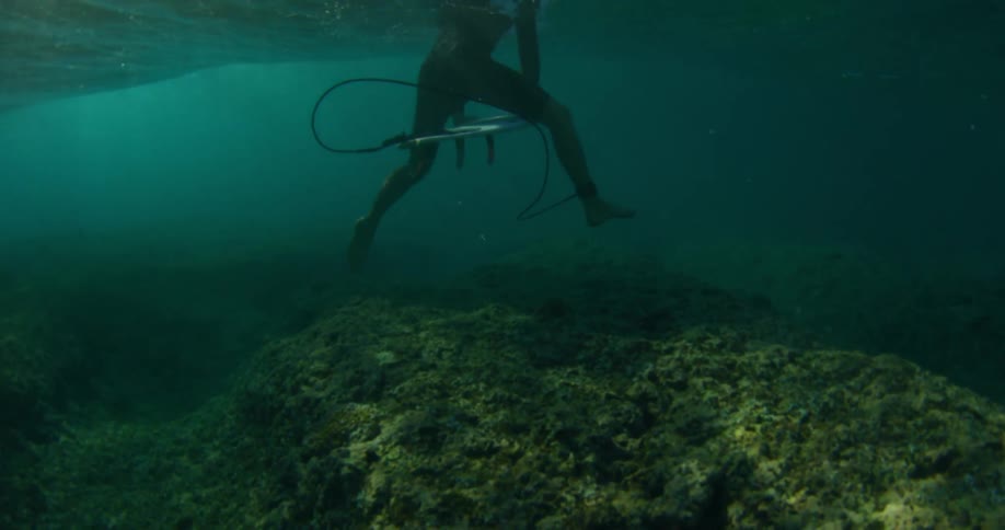 A male swimming and scuba diving underwater