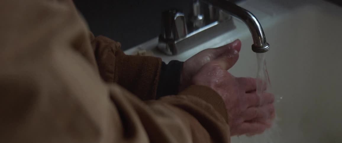 A person is washing his hands in the sink