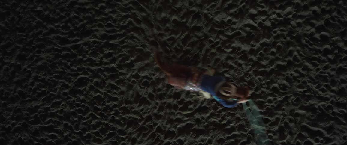 Ariel of a person on a horse swinging a lasso at a rodeo