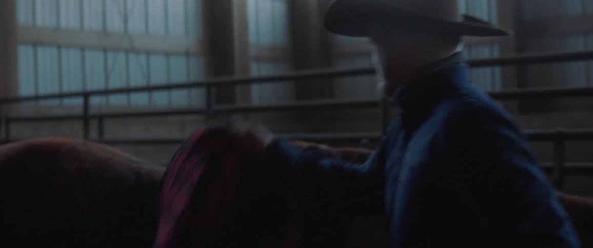 A man putting a saddle on a horse