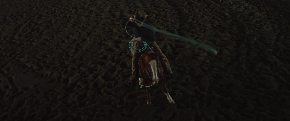 A man swinging a lasso on a horse