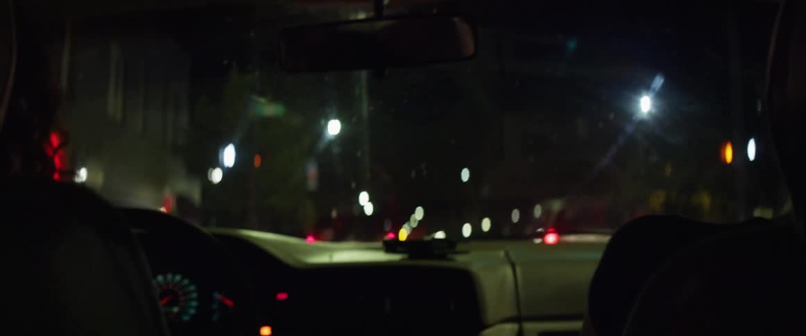 Two friends dancing while driving a car at night