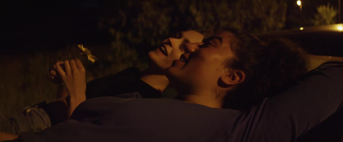 Two women lay on the car talking
